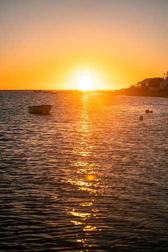 Zonsopgang aan de kust van de Algarve met boten en de sprankelende zee