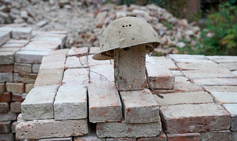 gestapelte Ziegel und alter Bauhelm auf einer Baustelle von Babetts Bildergalerie