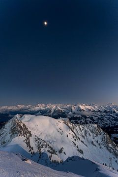 Maan boven de besneeuwde Alpen van Michael Zbinden Foto
