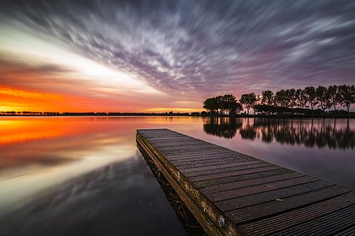 Steiger in het meer van Dirkshorn onder een indrukwekkende wolkenlucht tijdens rode zonsopkomst