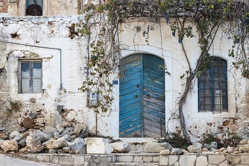 Old dilapidated blue door and windows in stone facade