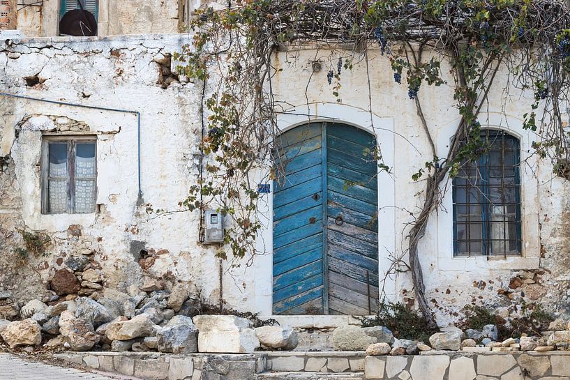 Vieille porte bleue délabrée et fenêtres sur une façade en pierre par Yke de Vos