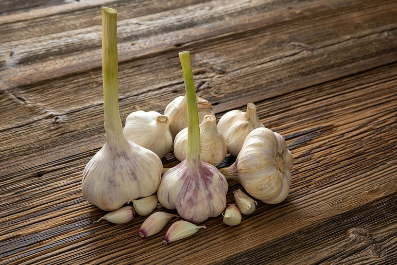 Garlic cloves stylised on weathered wooden boards by Photo Art Thomas Klee