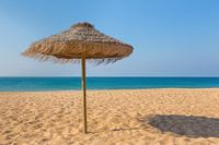 Wicker parasol on beach with blue sea and sky in Portugal
