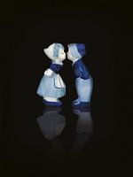 Liefde. Delfts blauw kussen paar, man en vrouw. Op zwarte achtergrond