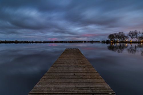 Houten steiger in het Meer van Dirkshorn onder wolkendek tijdens de schemering
