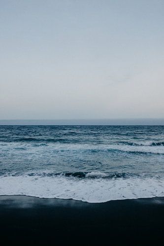 Zwart strand, blauwe zee, en witte golven in Tenerife