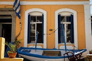 Façade méditerranéenne joyeuse avec bateau décoratif à Agios Nikolaos sur Paul de Kok