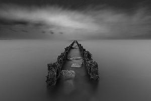 Pfähle und Steine im IJsselmeer bei Hindeloopen unter einem bedrohlich bewölkten Himmel