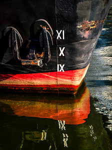 Spiegeling boeg van schip met anker in haven van Hamburg