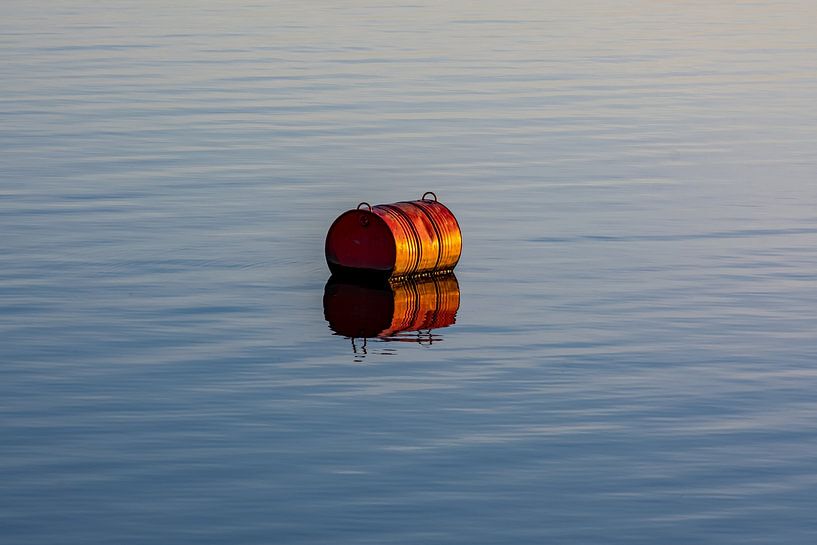 Red marker buoy in the water by Felix Marx