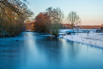 Bevroren water van een kanaal in een winterslandschap met sneeuw en herfstkleuren van Erwin van Eijden