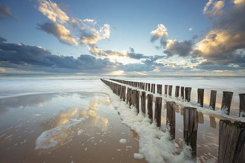 Zoutelande beach with a stormy raging sea full of foam heads
