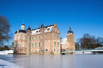 Medieval castle in the Netherlands with winter landscape and blue sky.