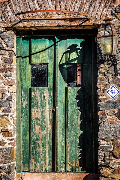 Vieille porte en bois vert avec une lanterne sur le mur par Jan van Dasler