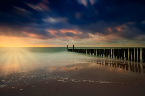Dutch clouds and typical breakwater of wooden poles along the coast of Zeeland