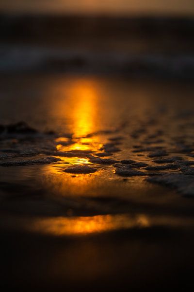 reflectie ondergaande zon op strand met dun laagje water van Margriet Hulsker