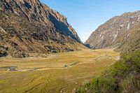 A tranquil valley between towering Andean peaks