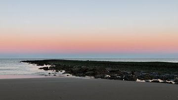 Verlaten pier aan het strand van Den Helder onder een gekleurde horizon. van Bram Lubbers