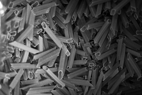 Rohe Snack-Cracker in Form von röhrenförmigen Penne – Textur – Monochrom