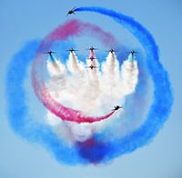 Red Arrows fighter jets with red, blue and white smoke