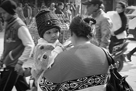 Girl on arm of mother in the busy streets of Kathmandu in Nepal by Erika van Elst