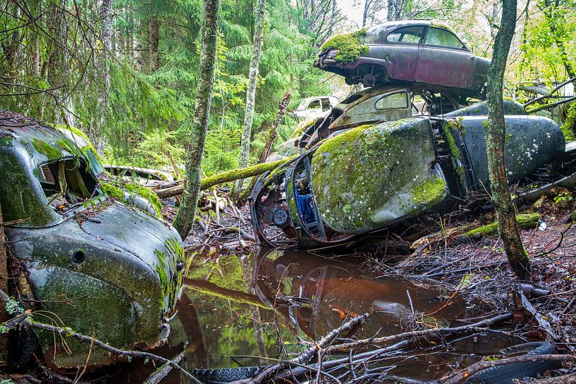Stacked car wrecks in the forest near Bastnas in Sweden by Evert Jan Luchies