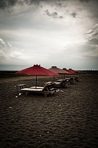 Kontrast zwischen dunklem Sand und stürmischem Himmel