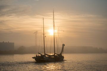 Zeilschip op de rivier passeert in de mist van scheepskijkerhavenfotografie