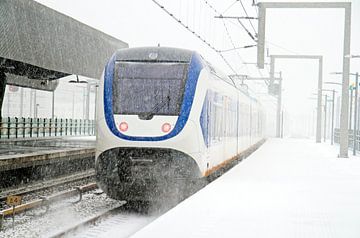 Rijdende trein in een sneeuwstorm in Amsterdam van Eye on You