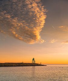 Stavoren's green lighthouse in an orange sunset by Harrie Muis