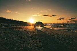 View through the glass ball on the beach. Sea and sky in the background. by Martin Köbsch