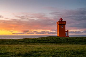 Zonsondergang met oranje vuurtoren van Henk Boerman