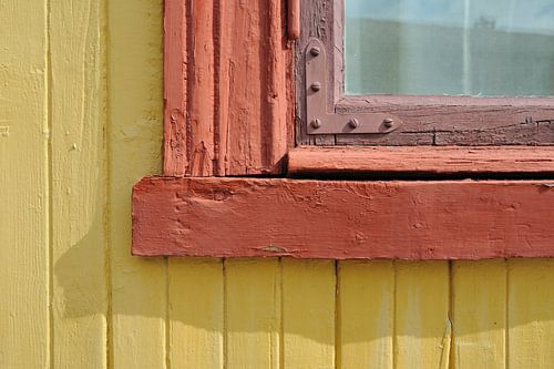 Raamkozijn van houten huis in geel en rood