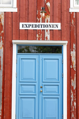 Rote Holzfassade mit blauer Tür