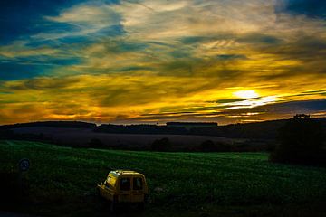 Zonsondergang met gele oude Renault van Philippe van Susan Hol