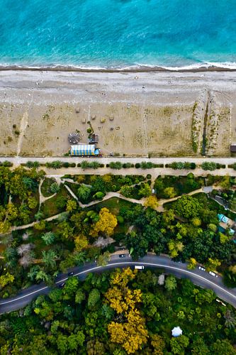 winding road among the green and yellow autumn forest. Aerial view from top to bottom of the turquoi