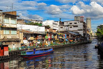 Klong waterkanaal met boot en huisgevels in Bangkok Thailand van Dieter Walther