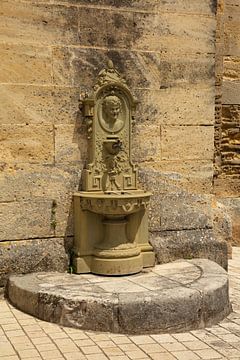 Fontein aan kerk in Frankrijk met duivelskopje van Joost Adriaanse