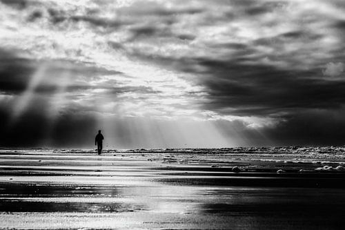 Zeegezicht met een wandelaar langs de kustlijn