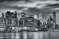 Black and white photograph of the skyline of Manhattan in New York, USA, at night. The light of the 
