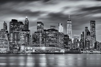 Schwarz-Weiß-Fotografie der Skyline von Manhattan in New York, USA, bei Nacht. Das Licht der Wolkenk