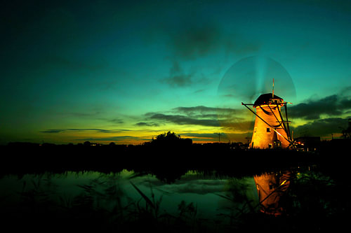 Kinderdijk molen bij ondergaande zon. Tijden de verlichte week met draaiende wieken