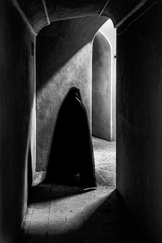 Vrouw loopt met haar schaduw door een kasteel | Iran