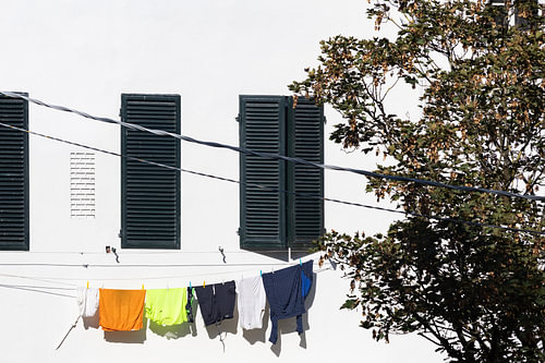 Waslijn met wasgoed dat hangt te drogen aan een monumentaal pand in Lucca, Toscane, Italië.
