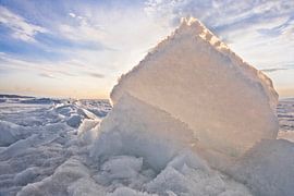 Yellow-orange light of the sun shines through an ice floe, a hummock on Lake Baikal in spring by Michael Semenov