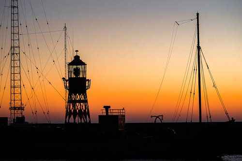 Contouren van een lichtschip in de haven bij zonsondergang