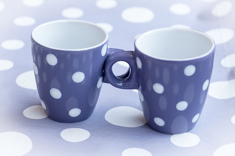 Zwei violette Kaffeebecher mit weißen Punkten auf fliederfarbenem Hintergrund mit weißen Punkten von Idema Media