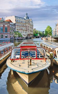 Retro stijl Tour boot met oude herenhuis in Amsterdam