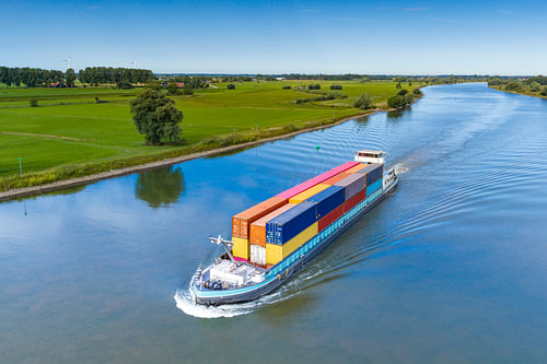 Container ship on a river seen from above